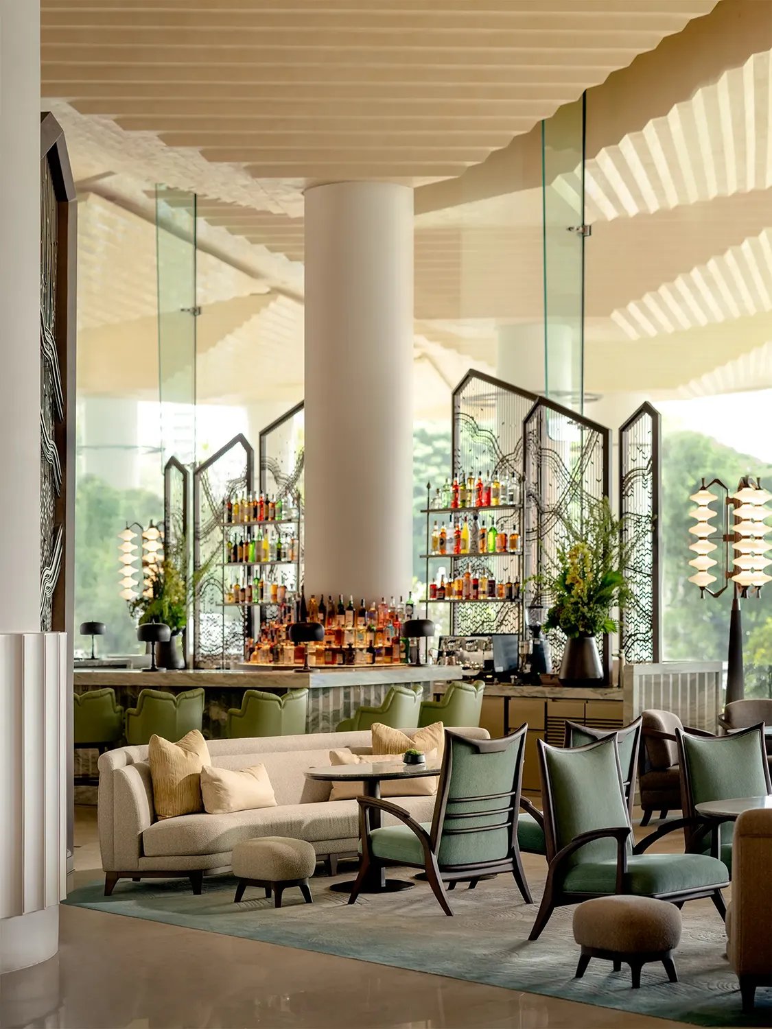 An indoor lounge space with well-designed furniture in front of a full bar for making mixed drinks