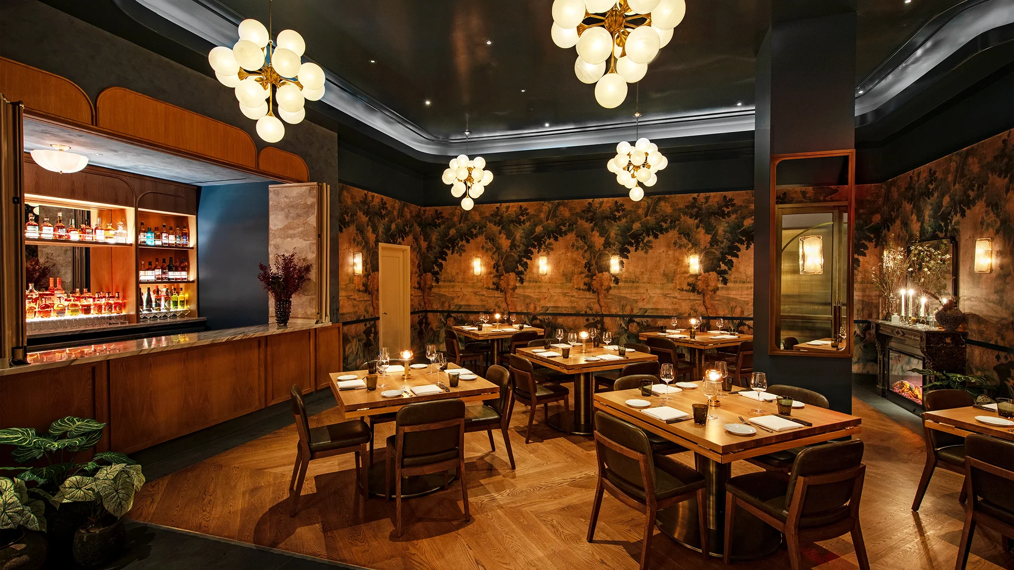 A restaurant dining room set with 5 tables ready for service and a speakeasy window looking into the bar